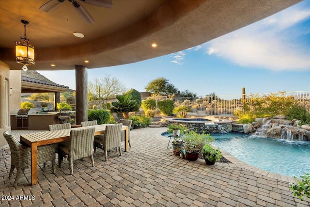 view of patio / terrace with ceiling fan, area for grilling, a swimming pool with hot tub, and pool water feature