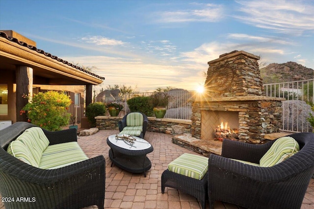 patio terrace at dusk with an outdoor stone fireplace