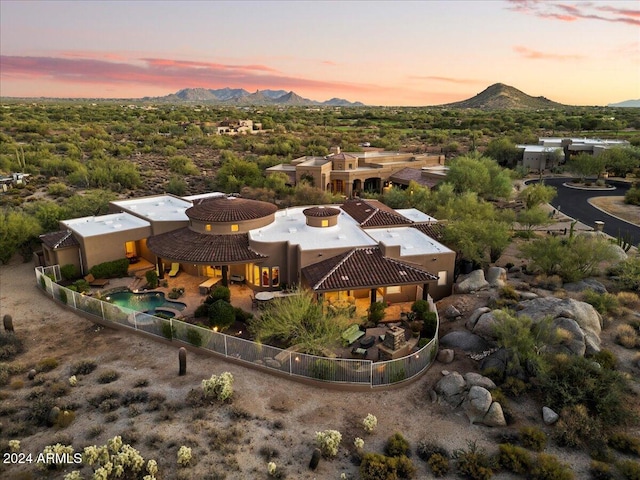 aerial view at dusk featuring a mountain view