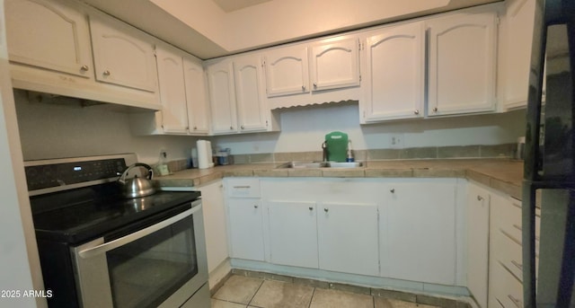 417 N 38th Ave, Phoenix, AZ 85009 - kitchen with stainless steel range with electric stovetop, a sink, tile countertops, white cabinetry, and freestanding refrigerator