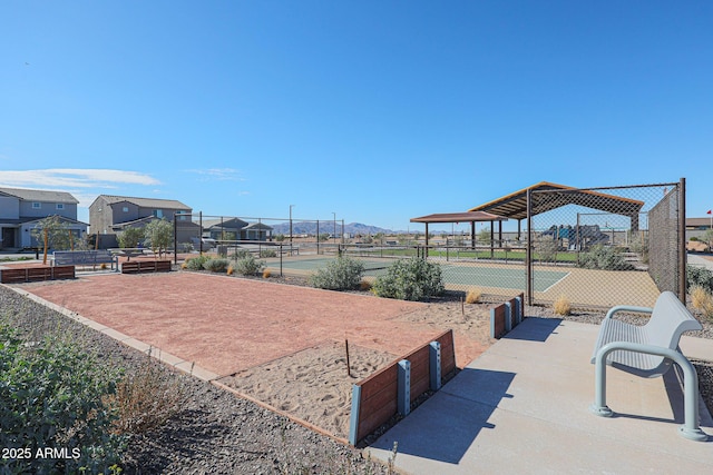 surrounding community featuring a tennis court and fence