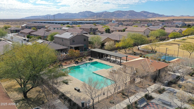 community pool featuring a residential view, a mountain view, and fence