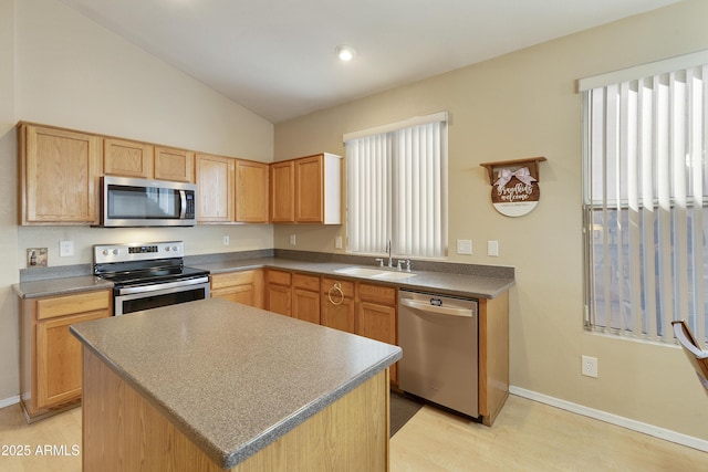 kitchen featuring sink, a center island, vaulted ceiling, light brown cabinets, and appliances with stainless steel finishes