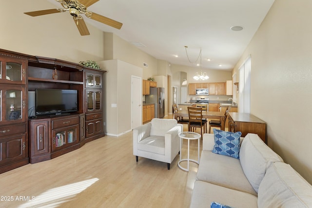 living room with ceiling fan with notable chandelier, light hardwood / wood-style floors, lofted ceiling, and sink