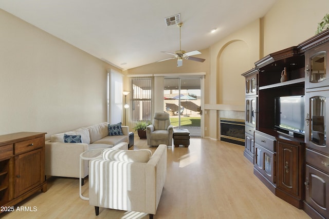 living room with ceiling fan, light wood-type flooring, and lofted ceiling