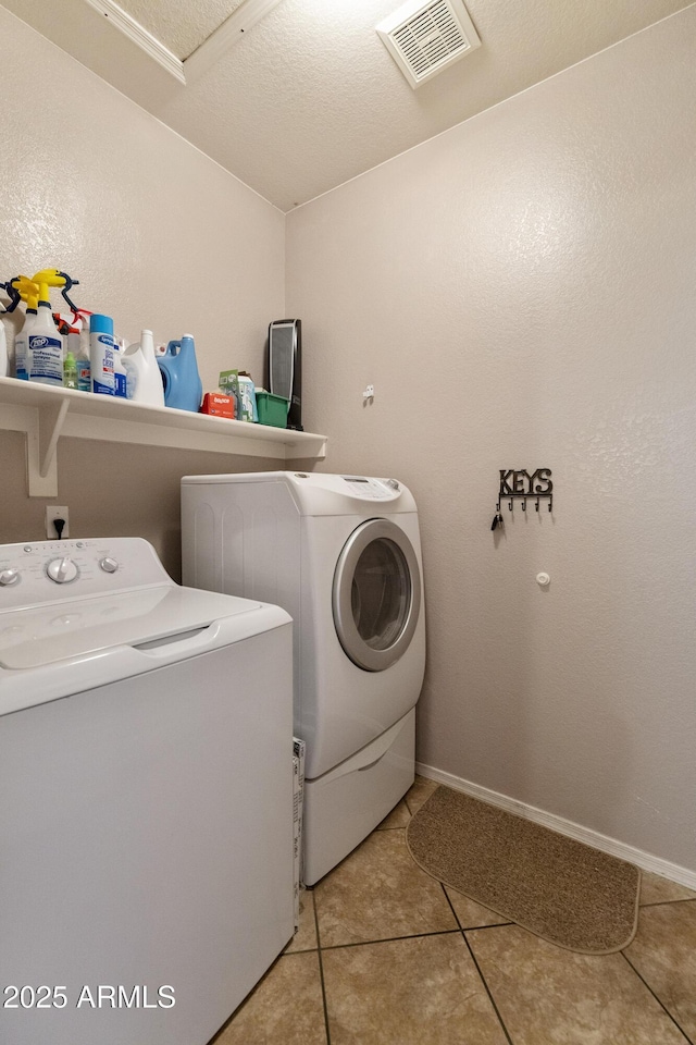 clothes washing area with light tile patterned flooring and washing machine and clothes dryer