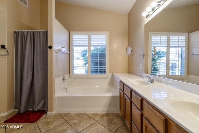 bathroom featuring vaulted ceiling, tile patterned floors, a tub to relax in, and vanity