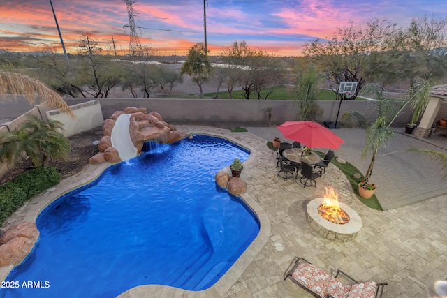 view of swimming pool with a fenced backyard, a patio, and a fire pit