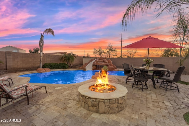 view of swimming pool with a patio, an outdoor fire pit, a fenced backyard, and a fenced in pool