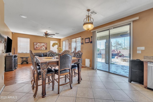 dining room with light tile patterned floors, baseboards, visible vents, and a ceiling fan