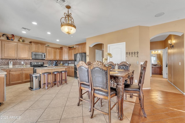 dining room featuring arched walkways, visible vents, recessed lighting, and light tile patterned floors