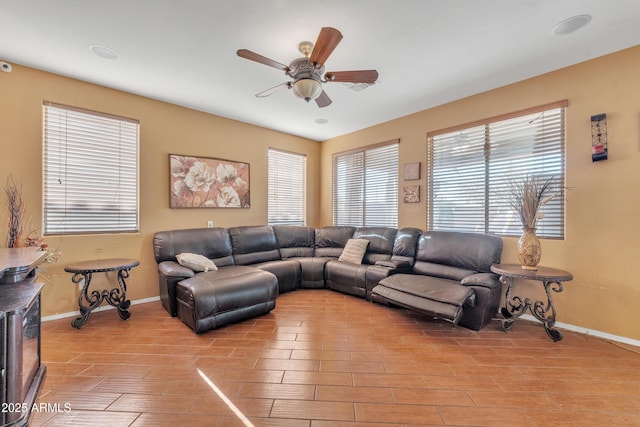 living room with wood tiled floor, baseboards, and a ceiling fan