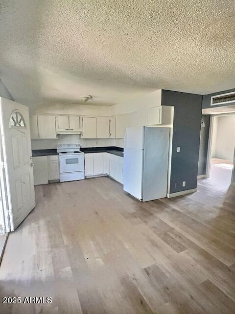 2957 E Atlanta Ave, Phoenix, AZ 85040 - kitchen featuring white appliances, a textured ceiling, white cabinets, light wood-type flooring, and under cabinet range hood
