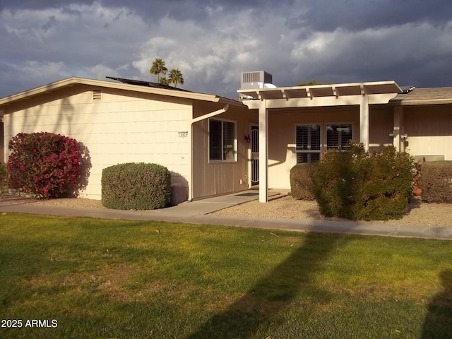 view of front facade with a front yard and central air condition unit