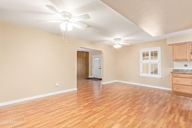 unfurnished living room featuring a textured ceiling, light hardwood / wood-style flooring, and ceiling fan