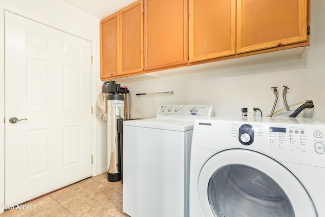 washroom with cabinets, separate washer and dryer, and light tile patterned floors