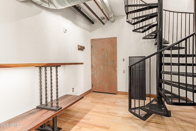 foyer featuring stairs, a towering ceiling, and wood finished floors