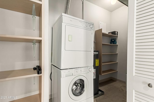 laundry room featuring laundry area, baseboards, stacked washing maching and dryer, and water heater