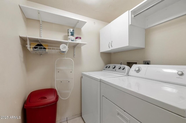 laundry area with washer and dryer, cabinets, and light tile patterned flooring