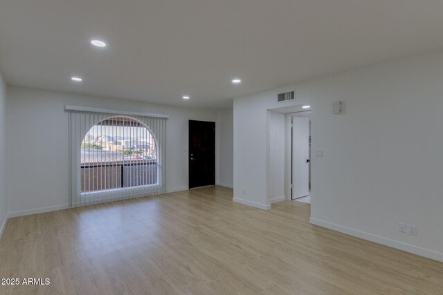 spare room featuring light wood-style flooring, recessed lighting, and baseboards