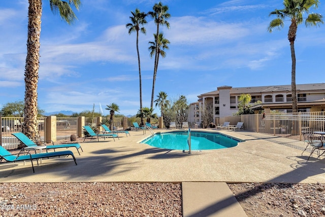 community pool featuring a patio and fence