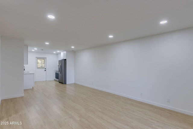 unfurnished living room with recessed lighting, light wood-style floors, and baseboards