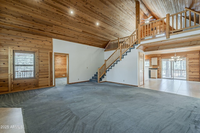 2793 Canyon Ridge Rd, Overgaard, AZ 85933 - unfurnished living room featuring baseboards, ceiling fan with notable chandelier, stairway, wooden walls, and high vaulted ceiling