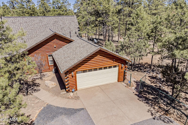 2793 Canyon Ridge Rd, Overgaard, AZ 85933 - view of side of property with a garage, a shingled roof, concrete driveway, and log siding