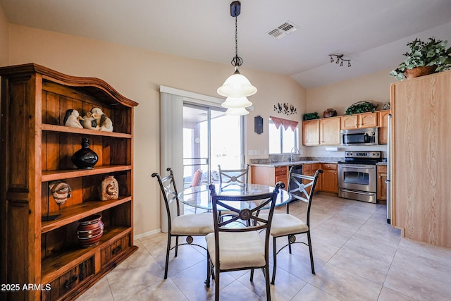 dining room featuring vaulted ceiling, sink, and light tile patterned floors