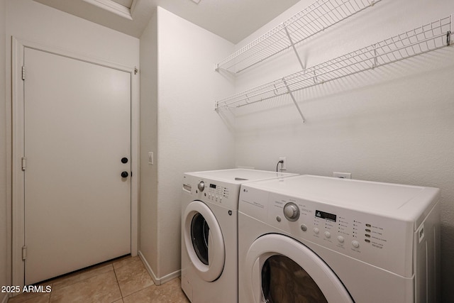 laundry room with washer and clothes dryer and light tile patterned floors