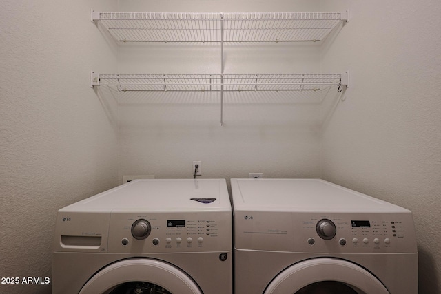 clothes washing area with washing machine and dryer