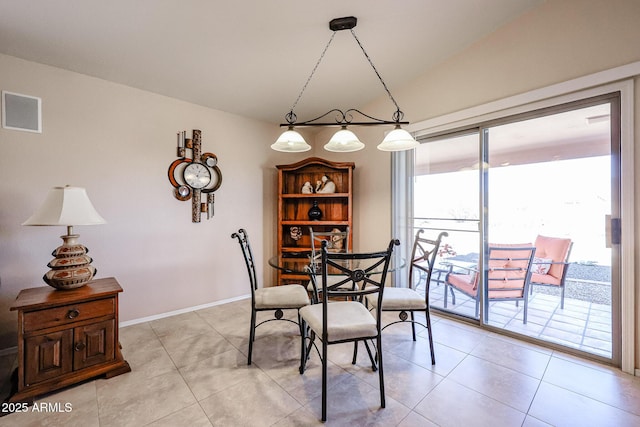 dining area featuring lofted ceiling and light tile patterned floors