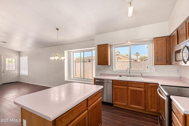 kitchen with dark wood-style flooring, light countertops, stainless steel appliances, a sink, and brown cabinetry