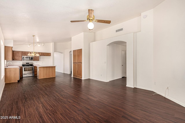 kitchen with arched walkways, visible vents, stainless steel appliances, and open floor plan
