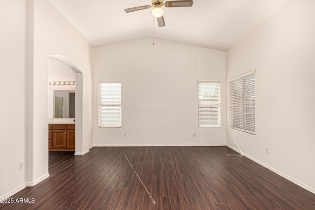 empty room featuring dark wood finished floors, lofted ceiling, a ceiling fan, and a healthy amount of sunlight