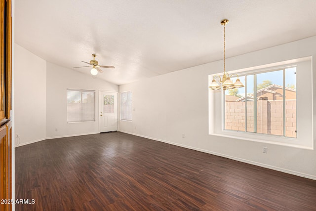 unfurnished room with ceiling fan with notable chandelier, lofted ceiling, baseboards, and dark wood-style floors