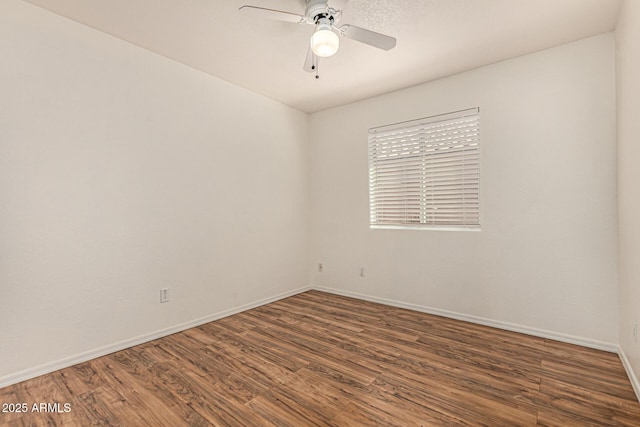 unfurnished room featuring baseboards, wood finished floors, and a ceiling fan