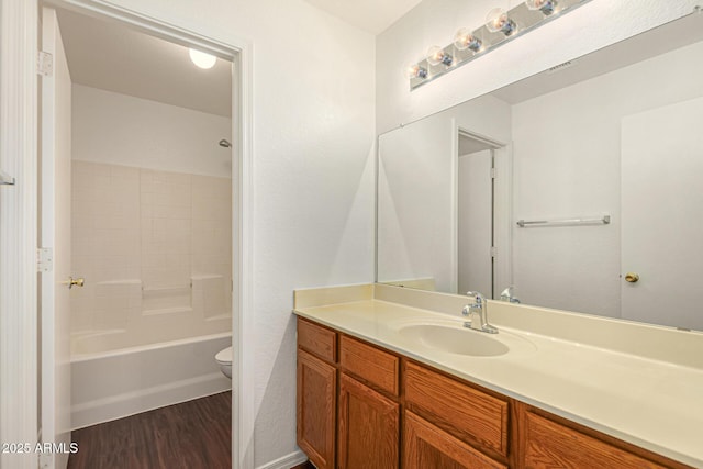 bathroom with toilet, vanity, shower / bathing tub combination, and wood finished floors