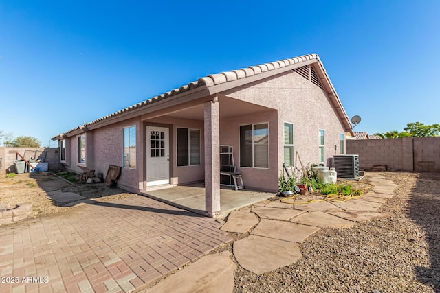 back of house with a patio area, stucco siding, fence, and central AC