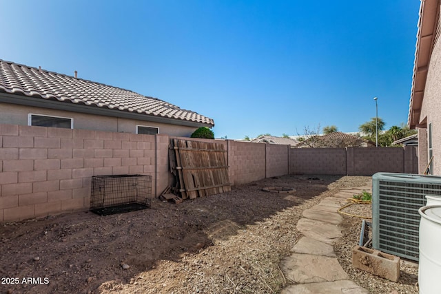 view of yard with central AC and a fenced backyard