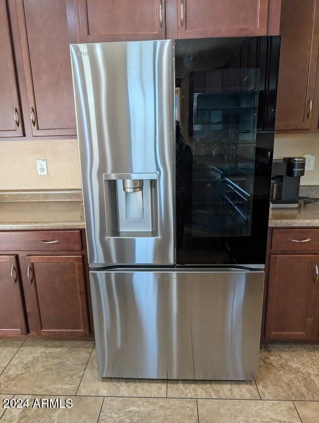 kitchen with light tile patterned floors and stainless steel fridge with ice dispenser