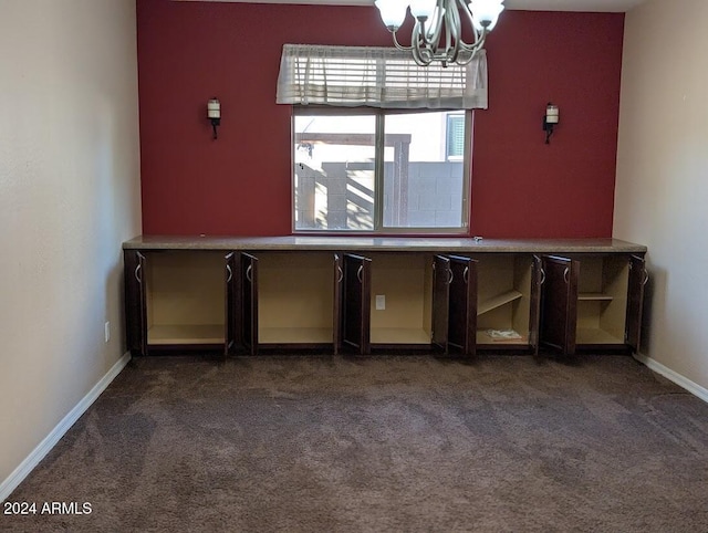 unfurnished dining area featuring dark carpet and a notable chandelier