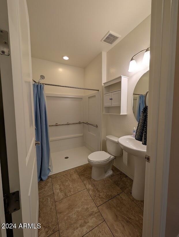 bathroom featuring curtained shower and toilet