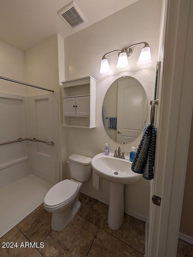 bathroom featuring toilet and a shower