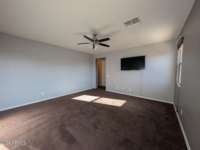 interior space with ceiling fan and dark colored carpet