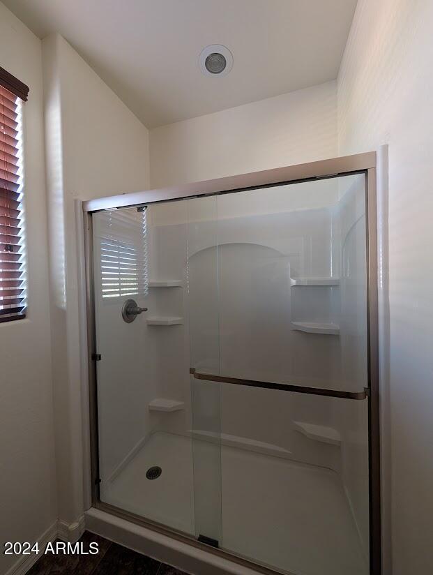 bathroom with tile patterned floors and a shower with door