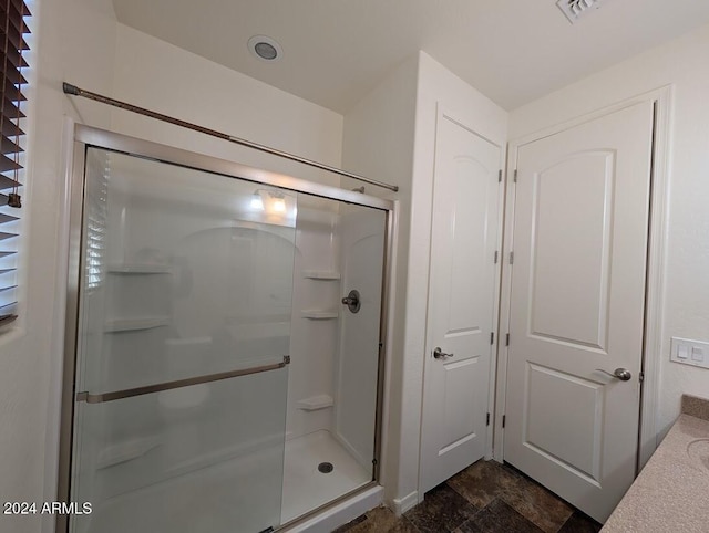 bathroom with vanity and a shower with door