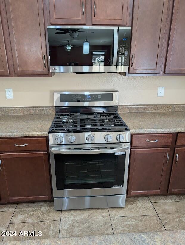 kitchen featuring light tile patterned flooring and appliances with stainless steel finishes