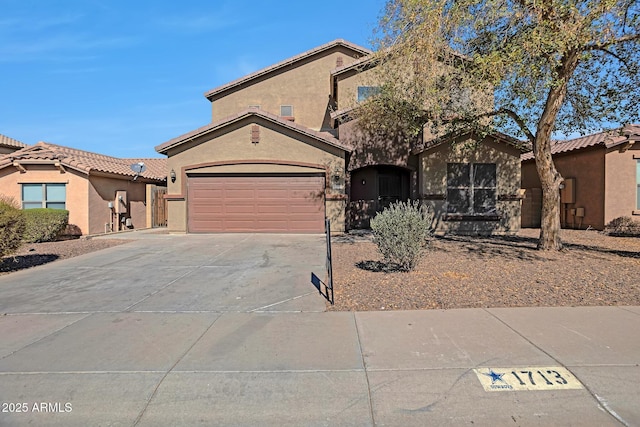 view of front of property featuring concrete driveway, a tile roof, an attached garage, and stucco siding