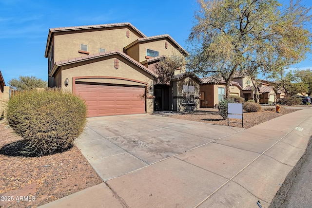 view of front of home featuring concrete driveway, a tiled roof, and stucco siding